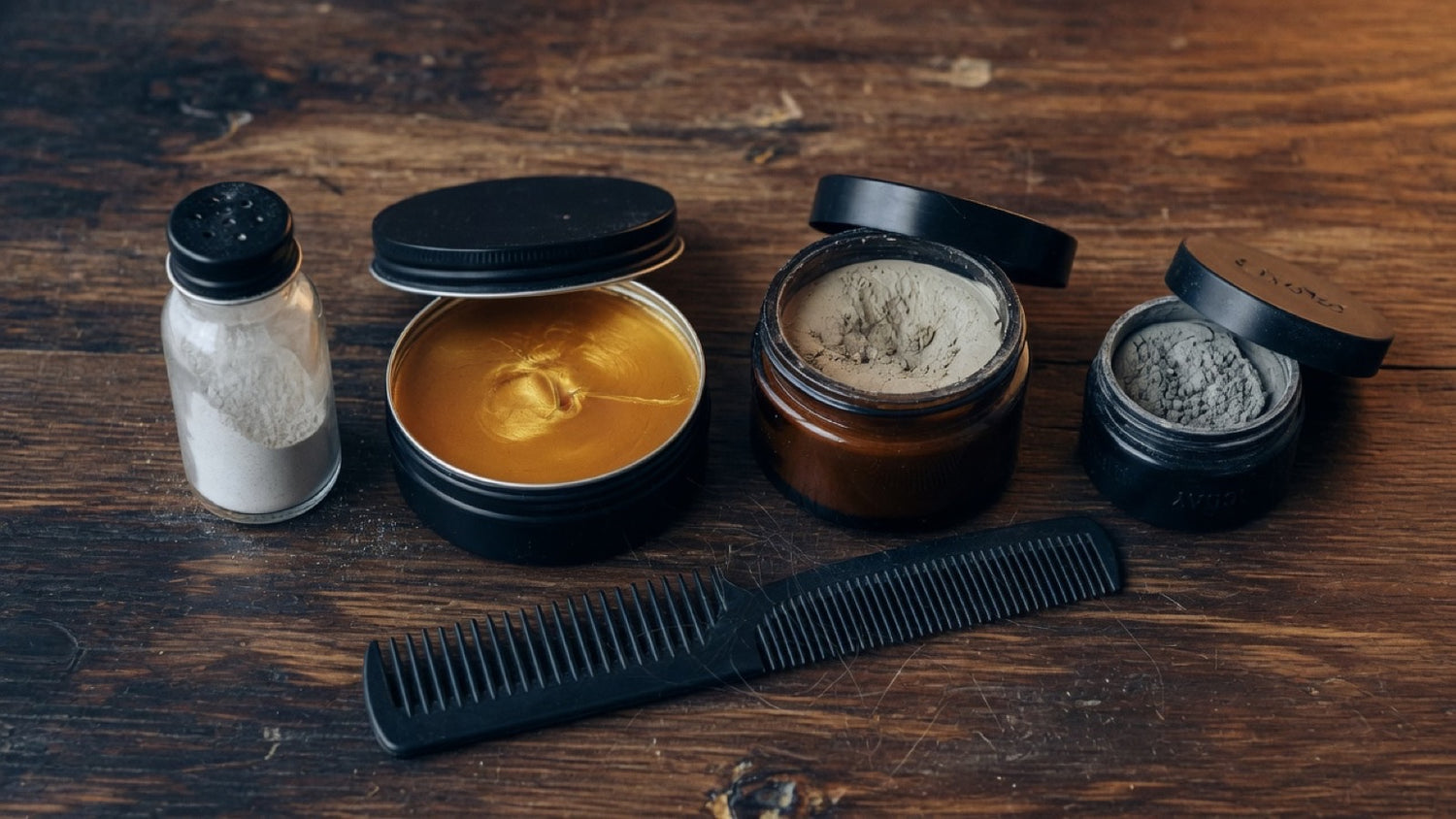 Texture powder, pomade, paste, and clay side by side on dark slate — men's hair product textures compared